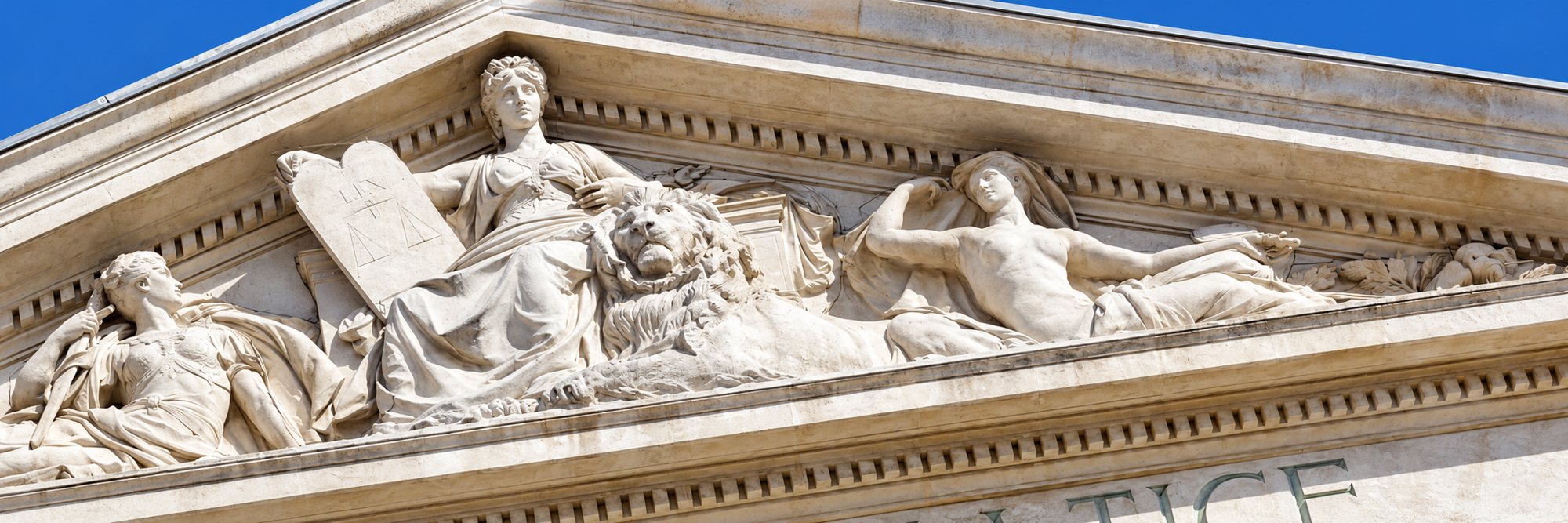 Façade d'un palais de justice, fronton sculpté et drapeau français