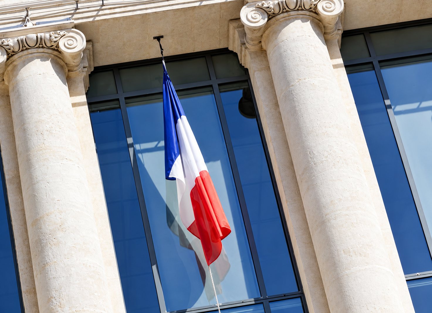 Façade d'un palais de justice, fronton sculpté et drapeau français